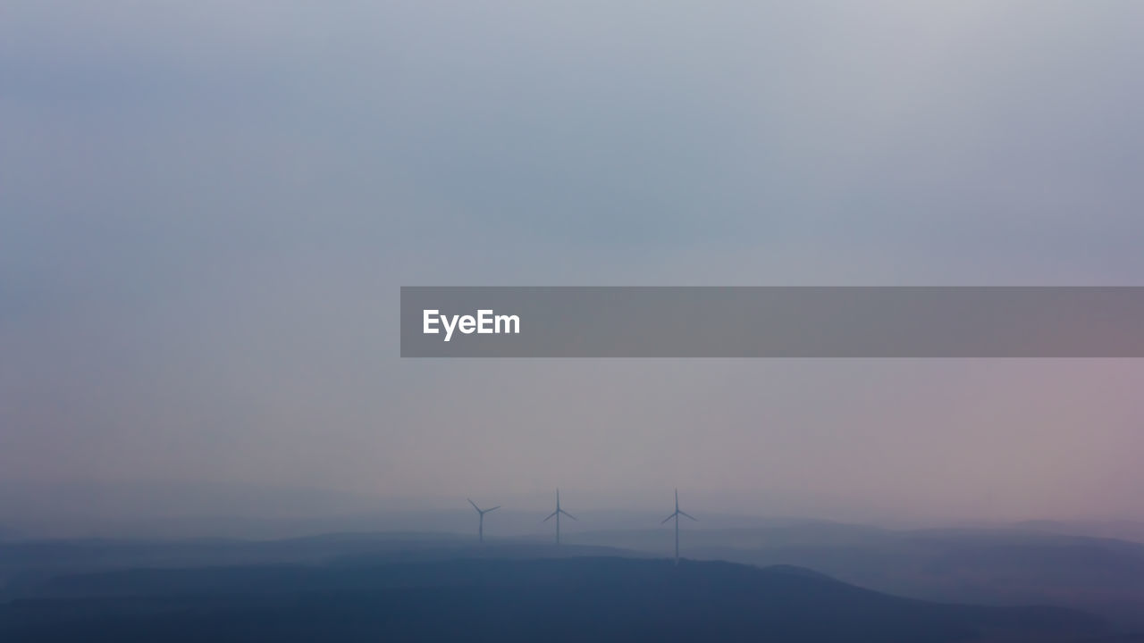 SILHOUETTE OF WIND TURBINE AGAINST SKY