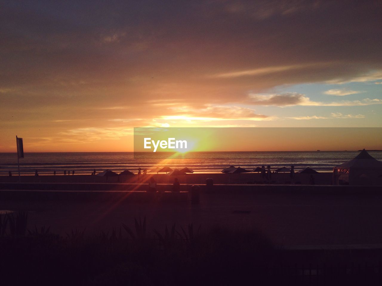 SCENIC VIEW OF BEACH AGAINST SKY DURING SUNSET