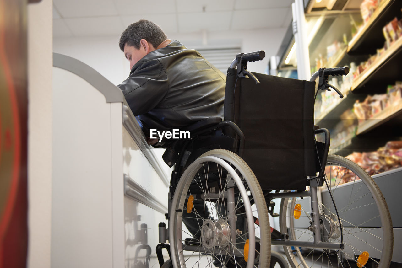 A disabled person in a wheelchair buys groceries