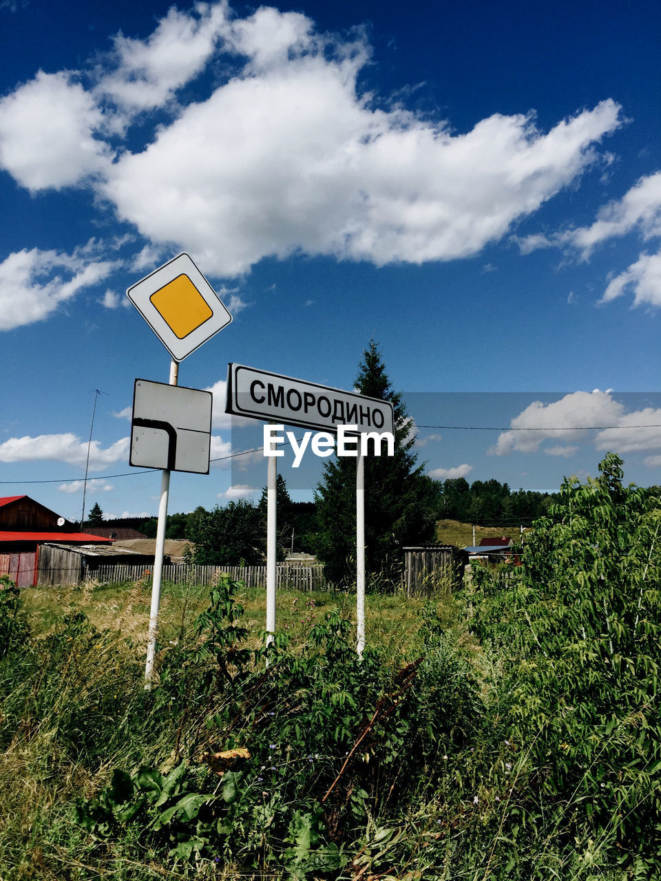 INFORMATION SIGN ON FIELD AGAINST ROAD