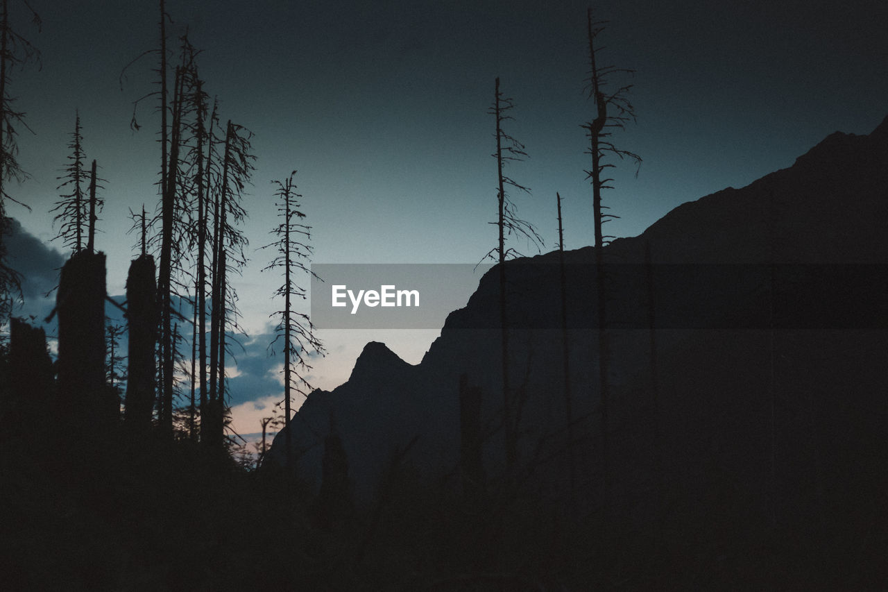 LOW ANGLE VIEW OF SILHOUETTE MOUNTAINS AGAINST CLEAR SKY AT SUNSET