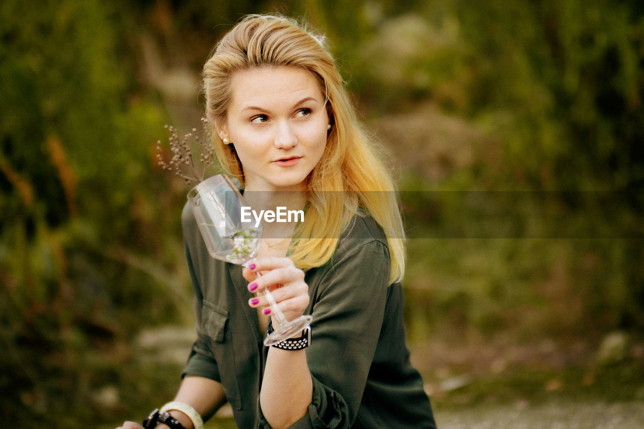 Portrait of young woman drinking glass