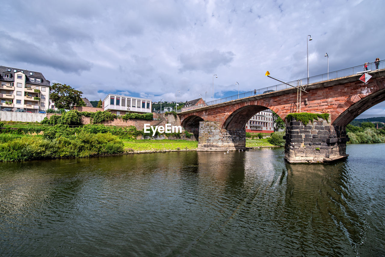 Arch bridge over river against sky