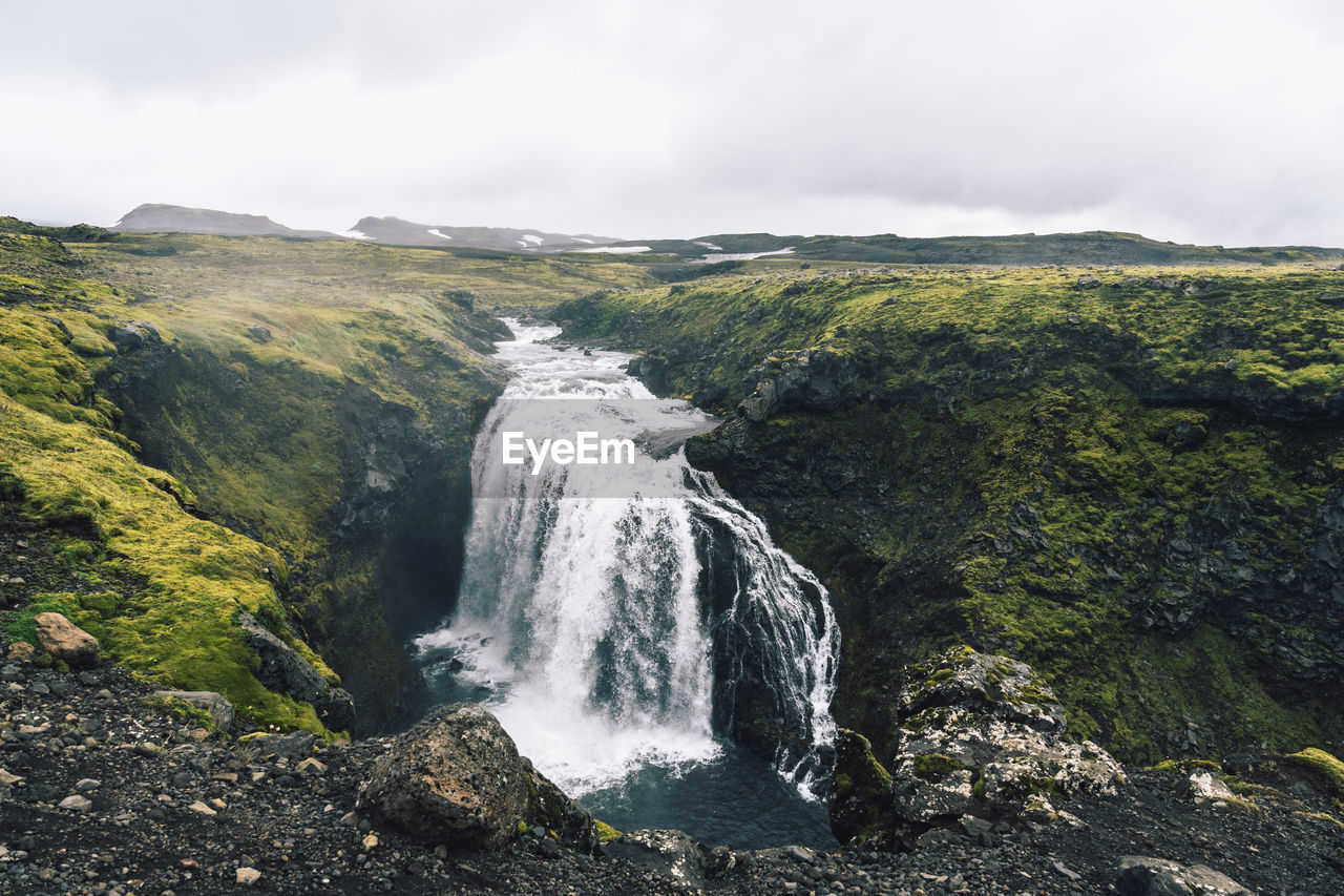 Waterfall in the beautiful landscape in icelandic environment during cloudy, misty day