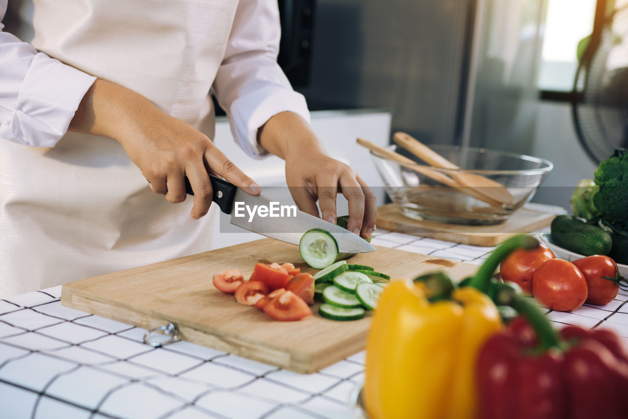 Midsection of man cutting vegetables on cutting board