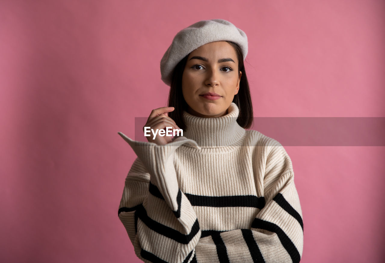 portrait of young woman standing against yellow wall