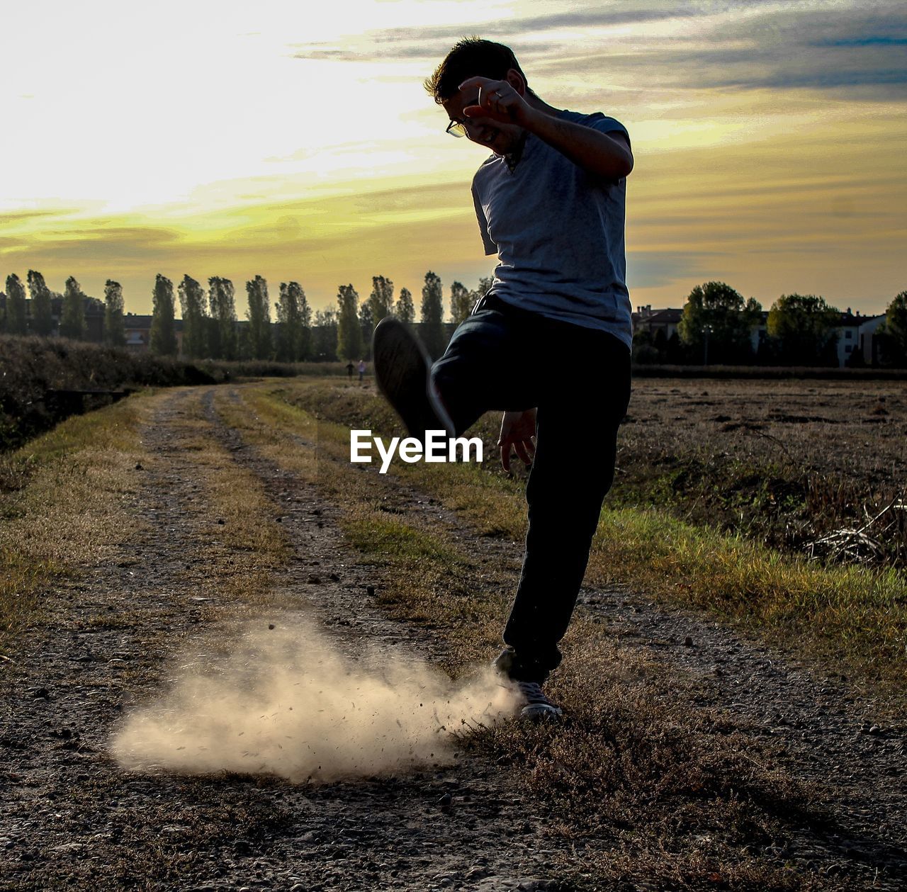 FULL LENGTH OF MAN RUNNING ON FIELD DURING SUNSET