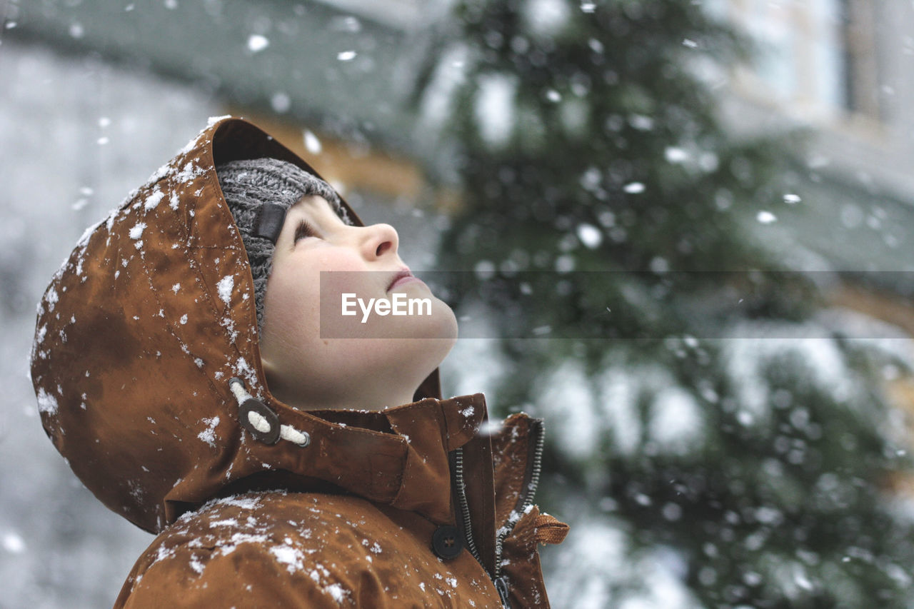 Boy looking up during snowy winter