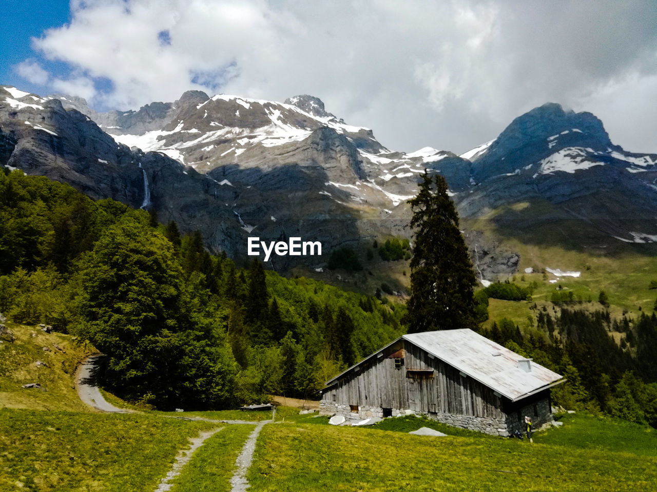 Scenic view of house and mountains against sky