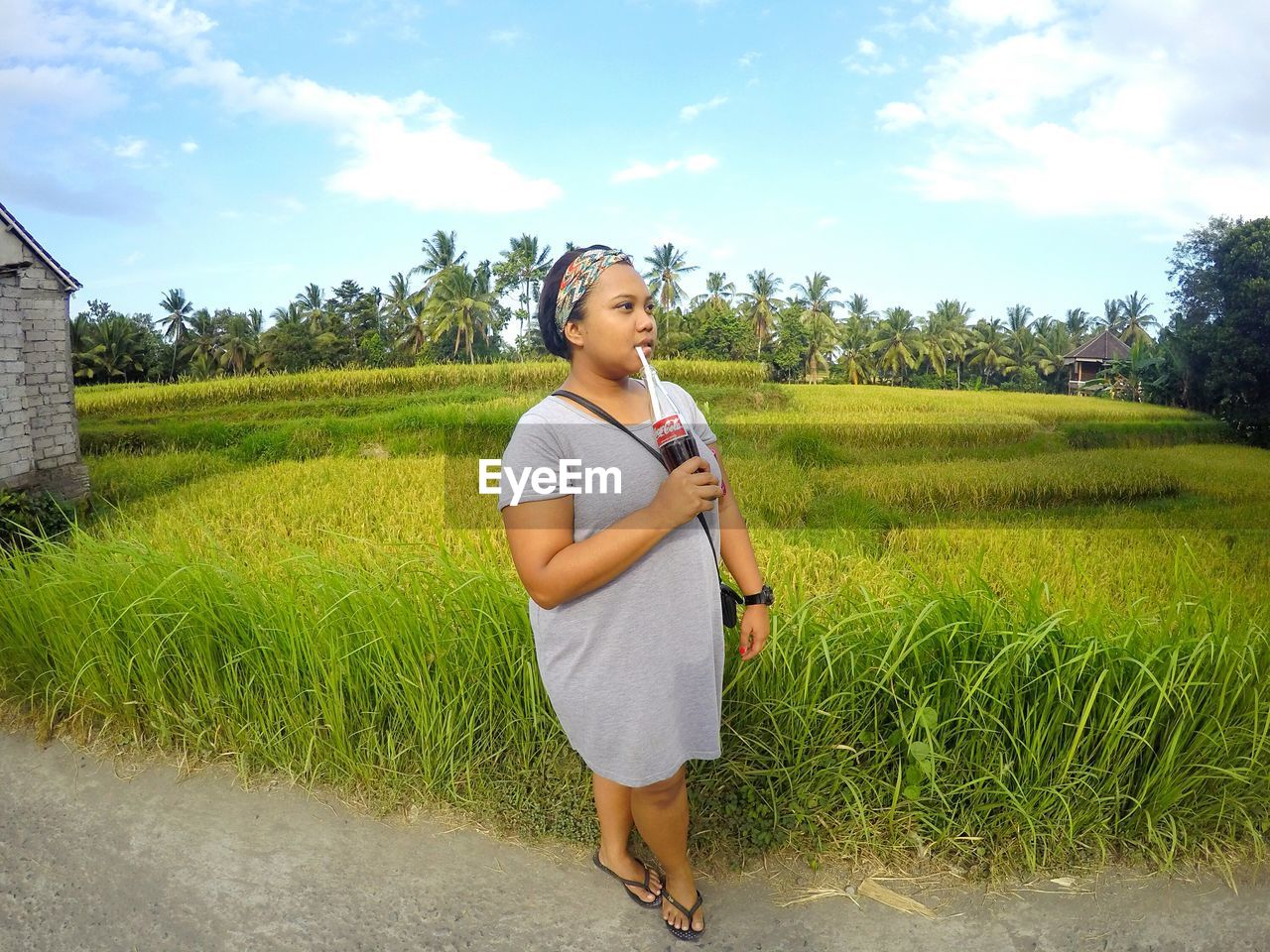 WOMAN STANDING ON GRASSY FIELD