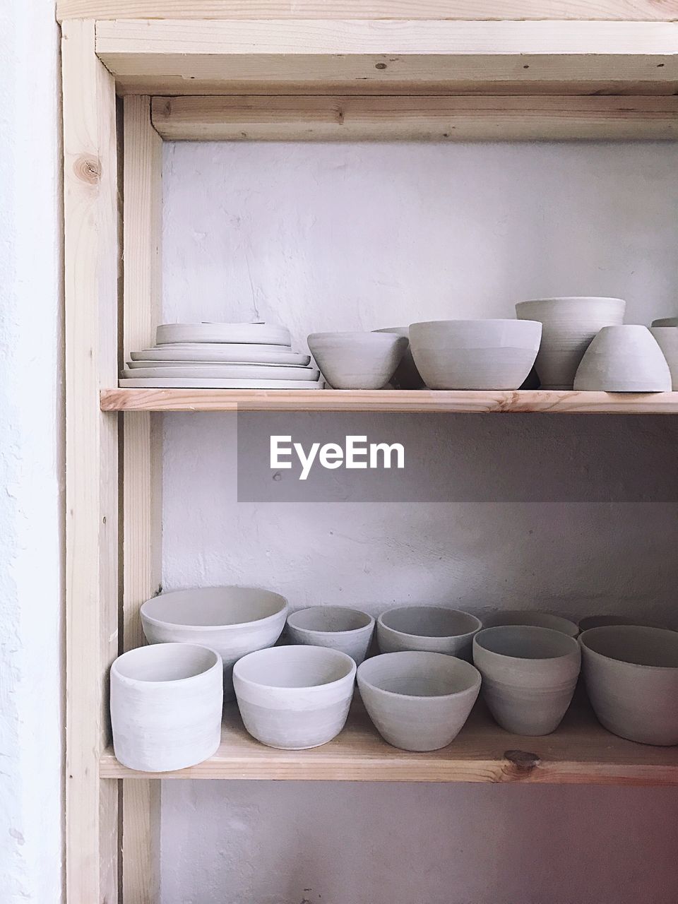 Crockery in shelf against wall