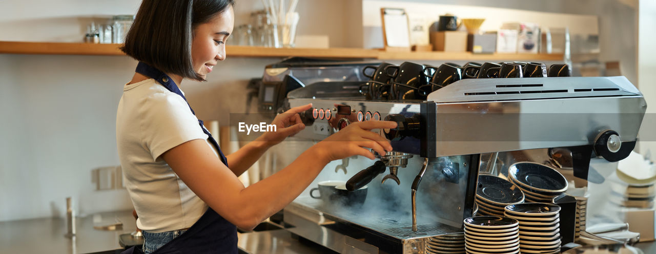 midsection of woman holding coffee at home