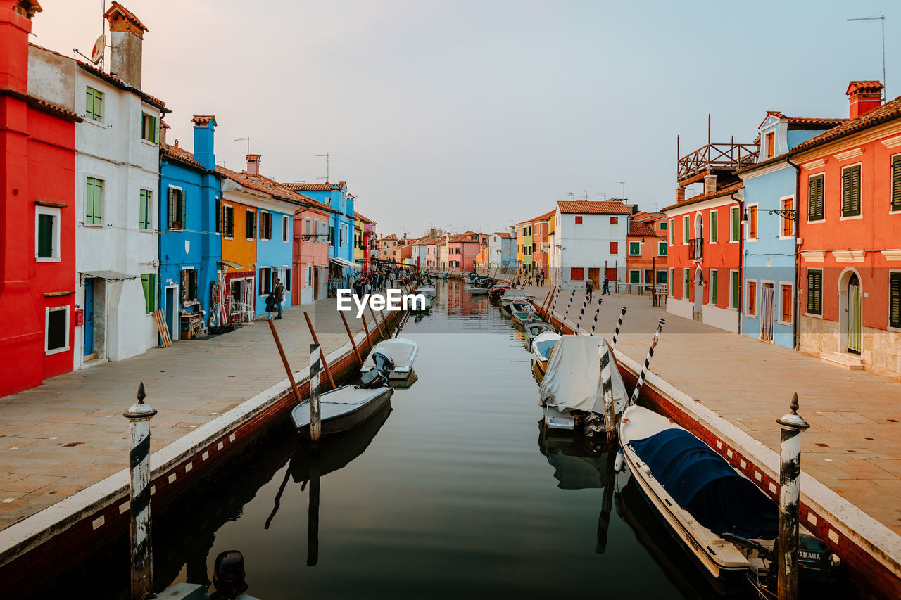 Picturesque canal street with tourists and colorful houses in burano