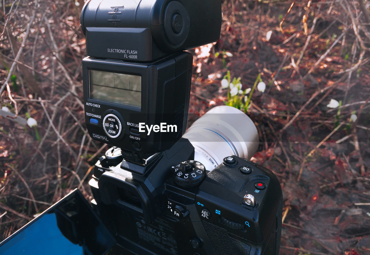 CLOSE-UP OF CAMERA ON FIELD BY CAR