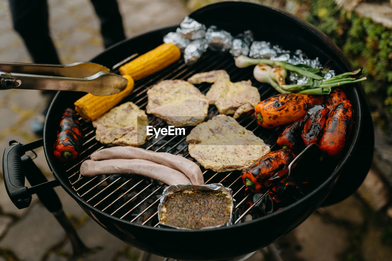 High angle view of meat and veggies on barbecue