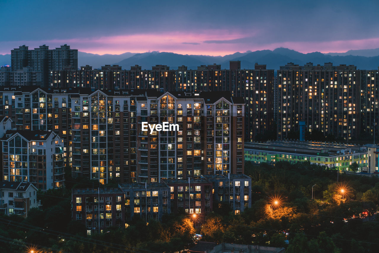 HIGH ANGLE VIEW OF ILLUMINATED BUILDINGS AGAINST SKY