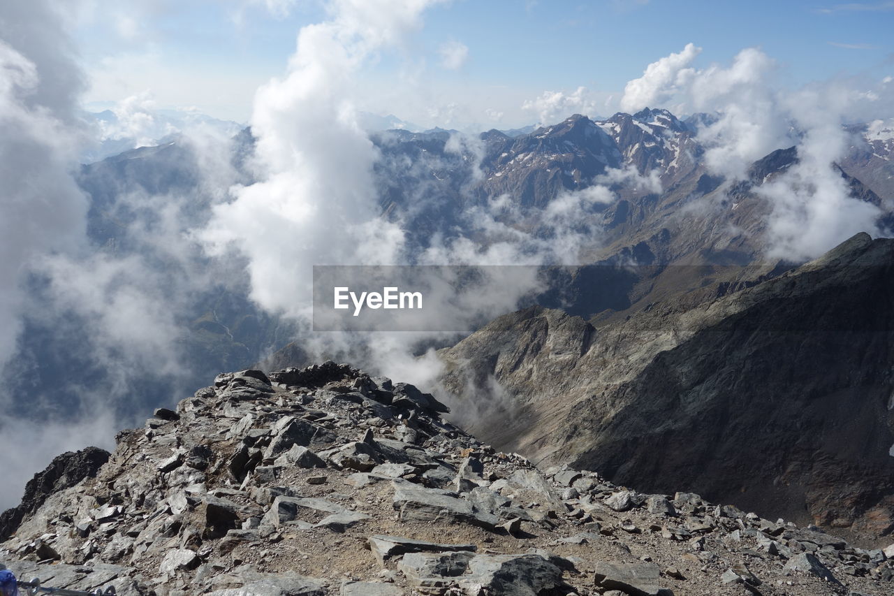 SCENIC VIEW OF MOUNTAINS AGAINST CLOUDY SKY