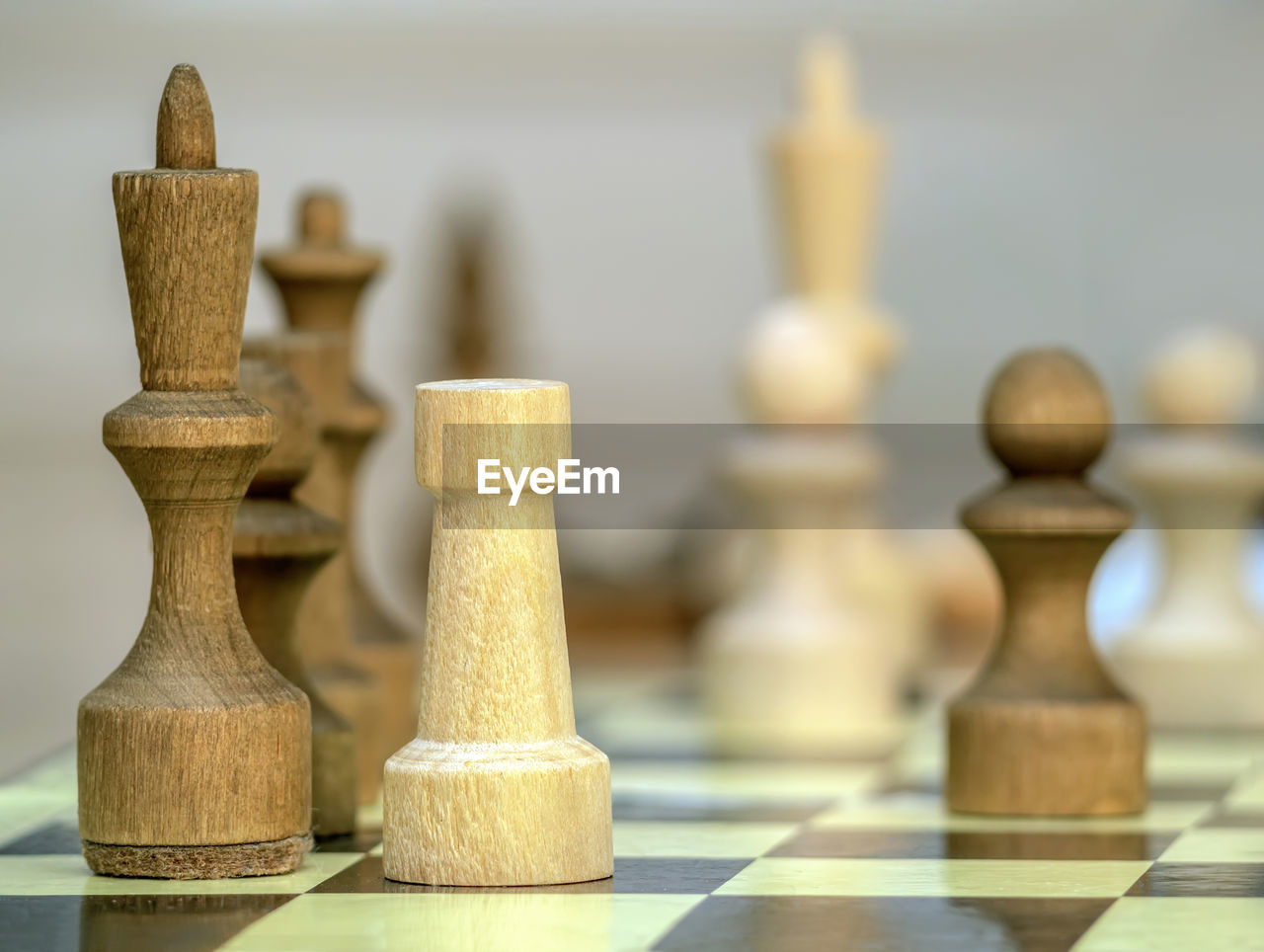 Vintage wooden chess pieces on the chess board. black king and whtite rook. close-up.