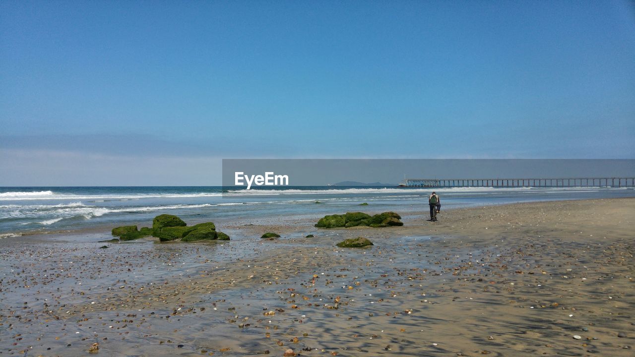 Man cycling along beach