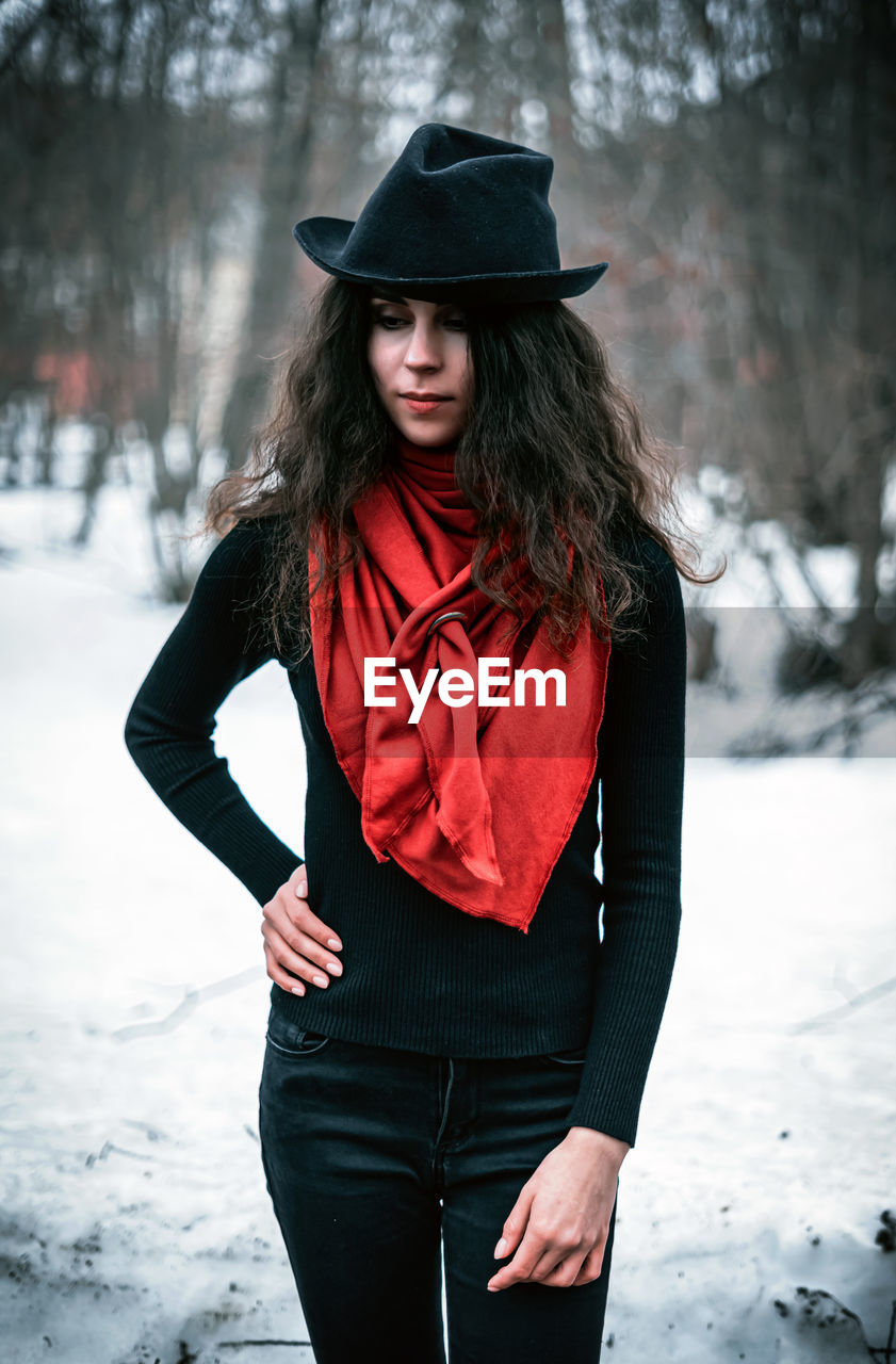 Woman wearing hat standing on snow covered land