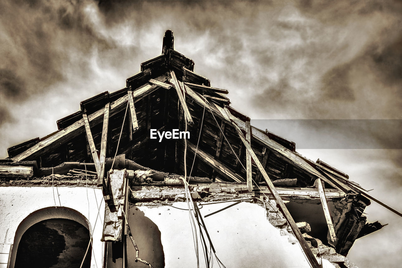 LOW ANGLE VIEW OF ABANDONED BOAT AGAINST CLOUDY SKY