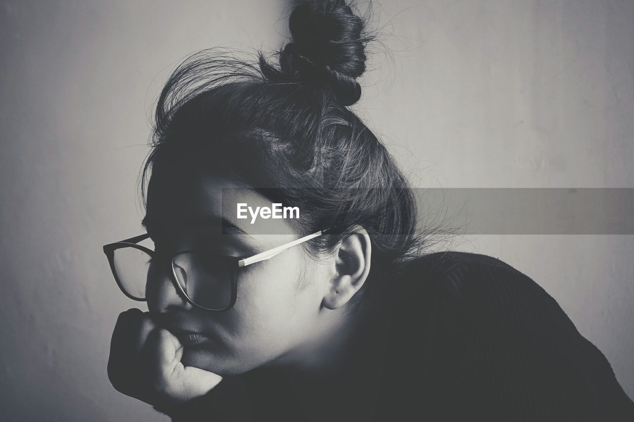 Close-up of girl wearing eyeglasses against white background