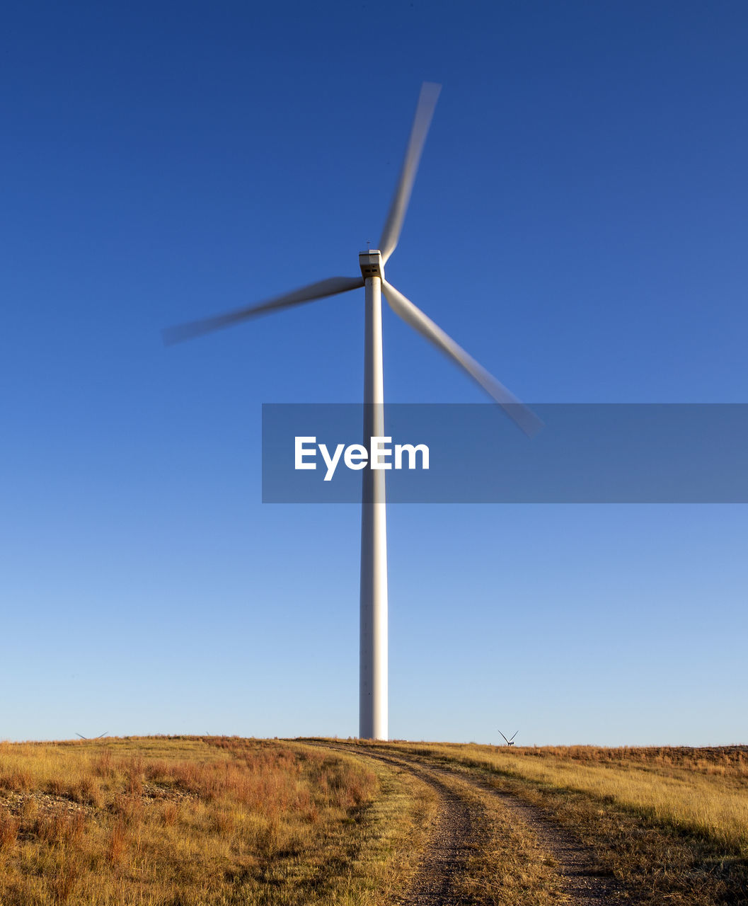 Wind turbine in motion against blue sky