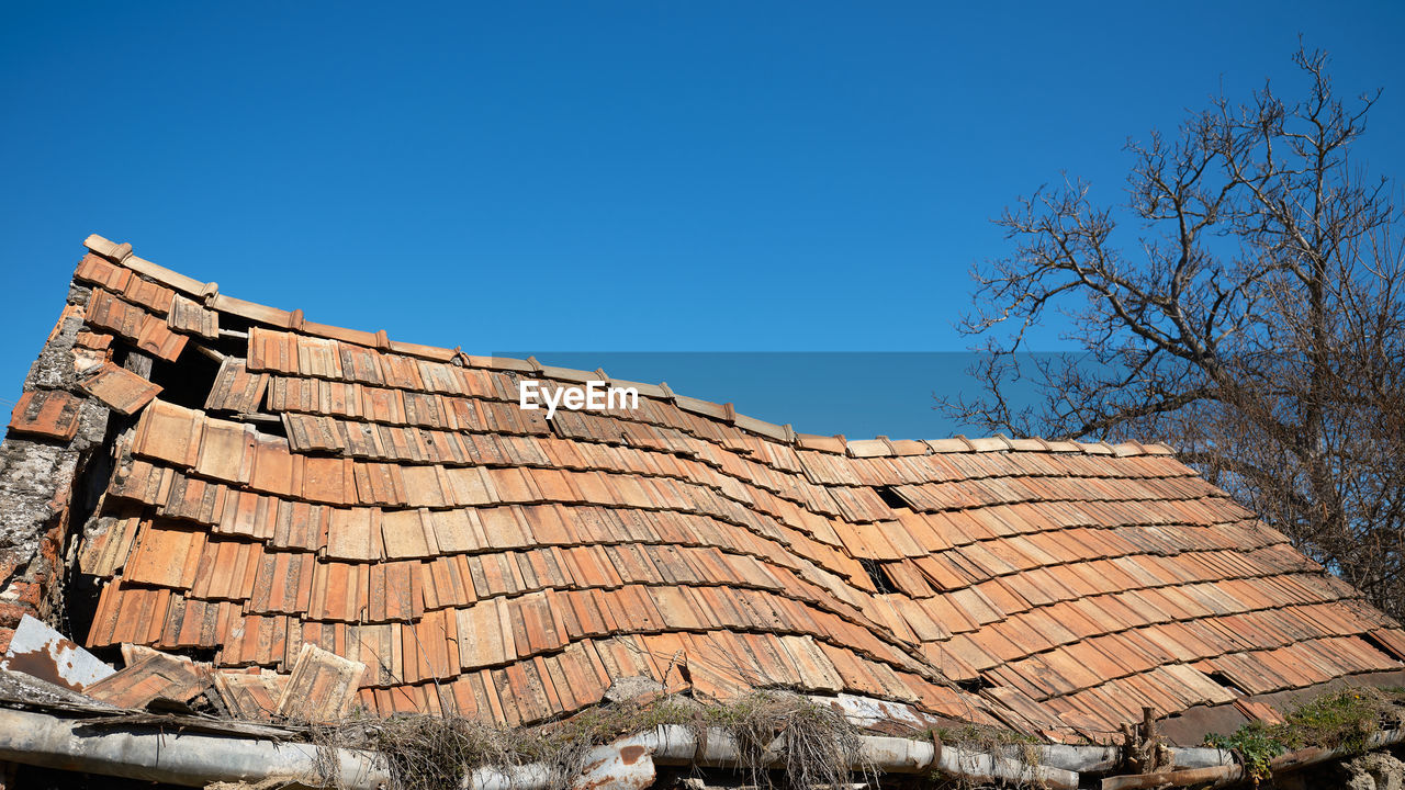 architecture, sky, roof tile, roof, built structure, nature, tree, blue, clear sky, building exterior, no people, building, house, day, wall, outdoor structure, outdoors, plant, bare tree, history, brick, sunny, the past, ruins