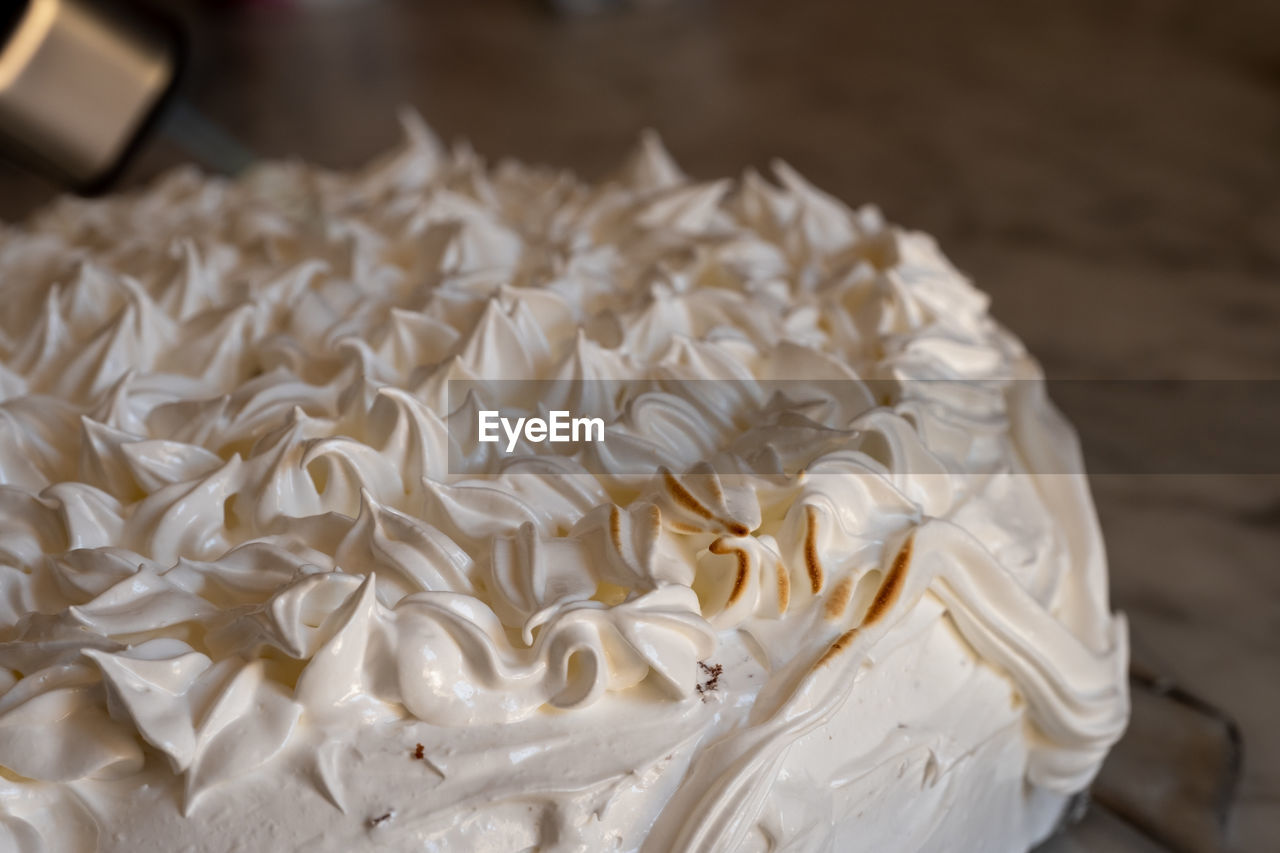 CLOSE-UP OF WHITE CAKE ON TABLE