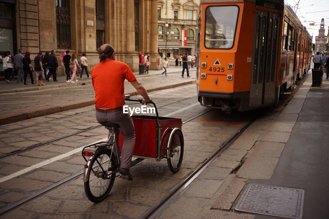 REAR VIEW OF A MAN MOVING ON ROAD