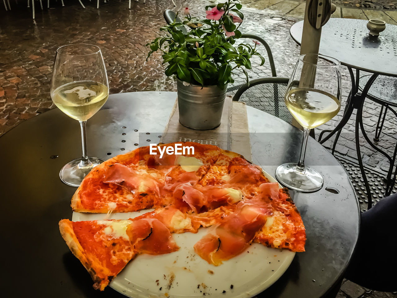 Close-up of pizza with wine glasses