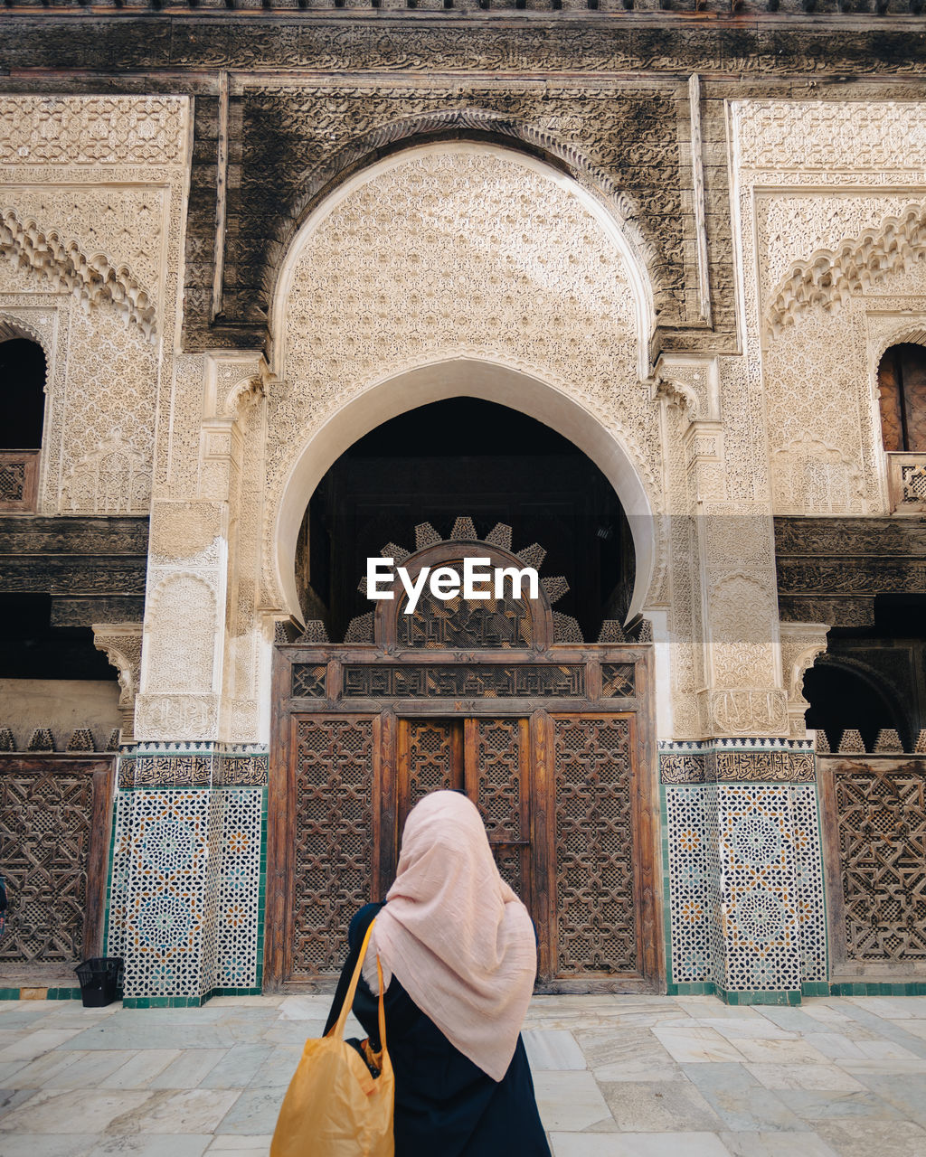architecture, arch, religion, built structure, rear view, place of worship, one person, travel destinations, ancient history, adult, travel, building exterior, history, the past, belief, clothing, tourism, person, spirituality, temple, women, traditional clothing, lifestyles, building, full length, day, entrance, outdoors, city