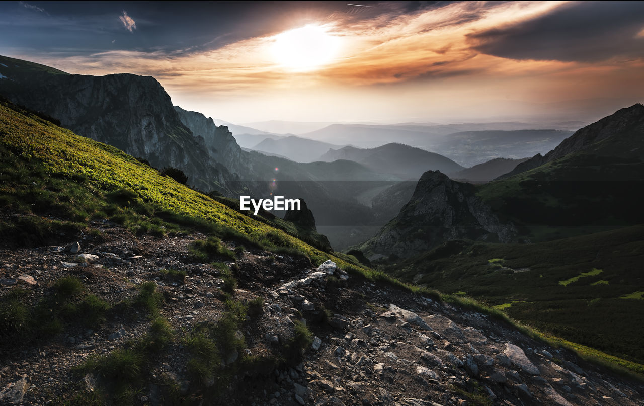 Scenic view of landscape and mountains against cloudy sky