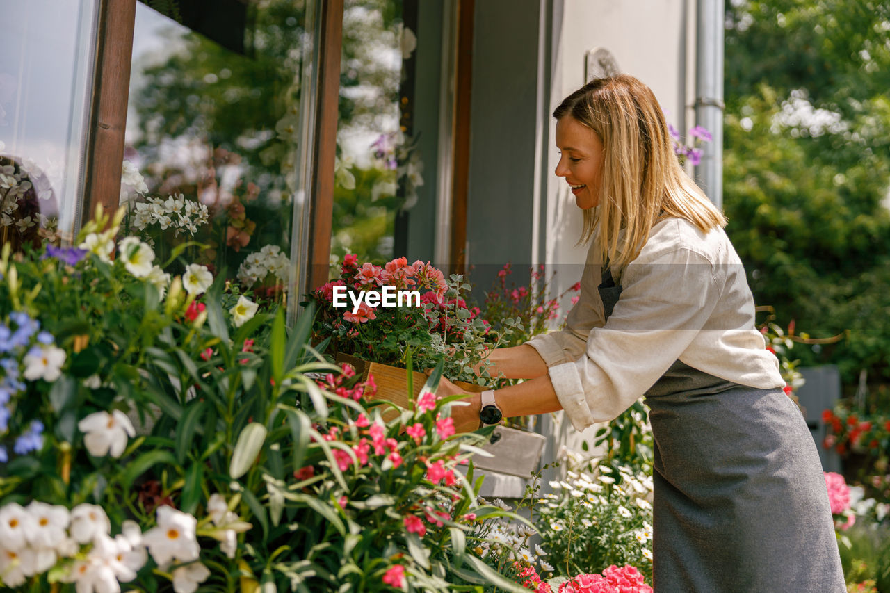 side view of young woman standing by plants