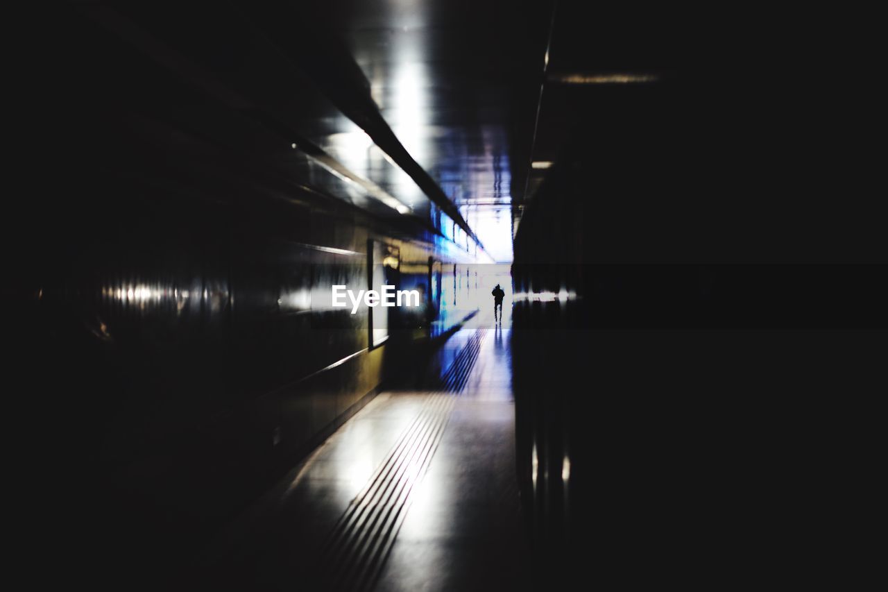 ILLUMINATED TUNNEL IN UNDERGROUND WALKWAY