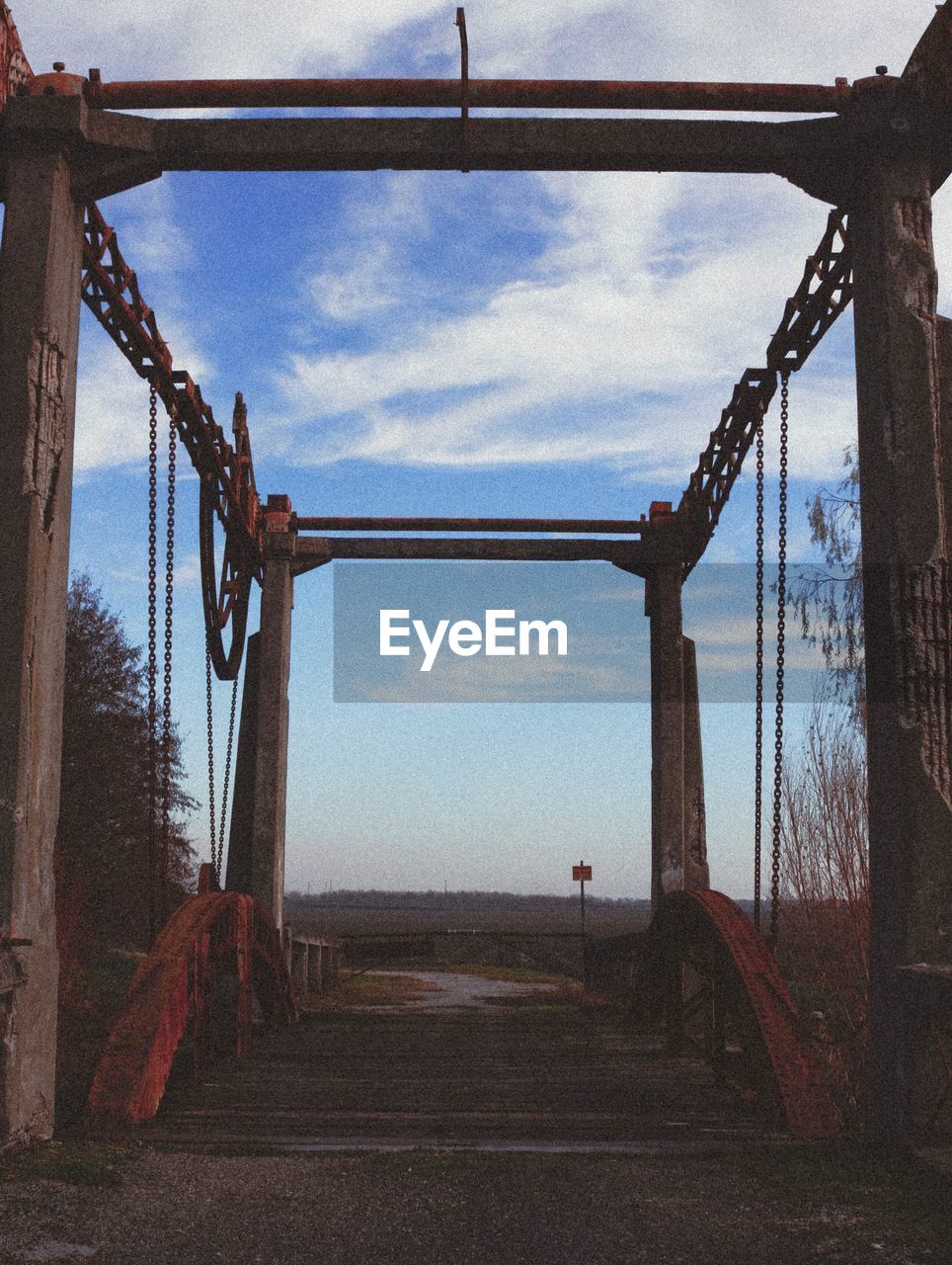 BRIDGE AGAINST SKY SEEN THROUGH METAL STRUCTURE