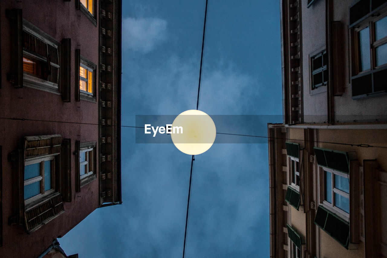 Low angle view of illuminated street light against sky