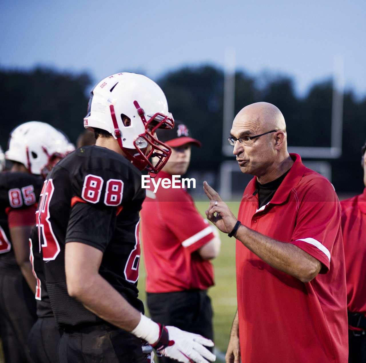 Coach explaining american football players on field