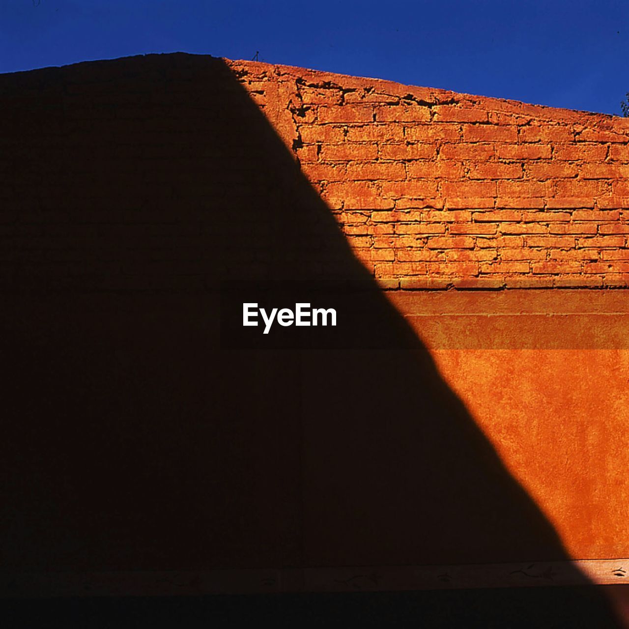 Shadow falling on brick wall