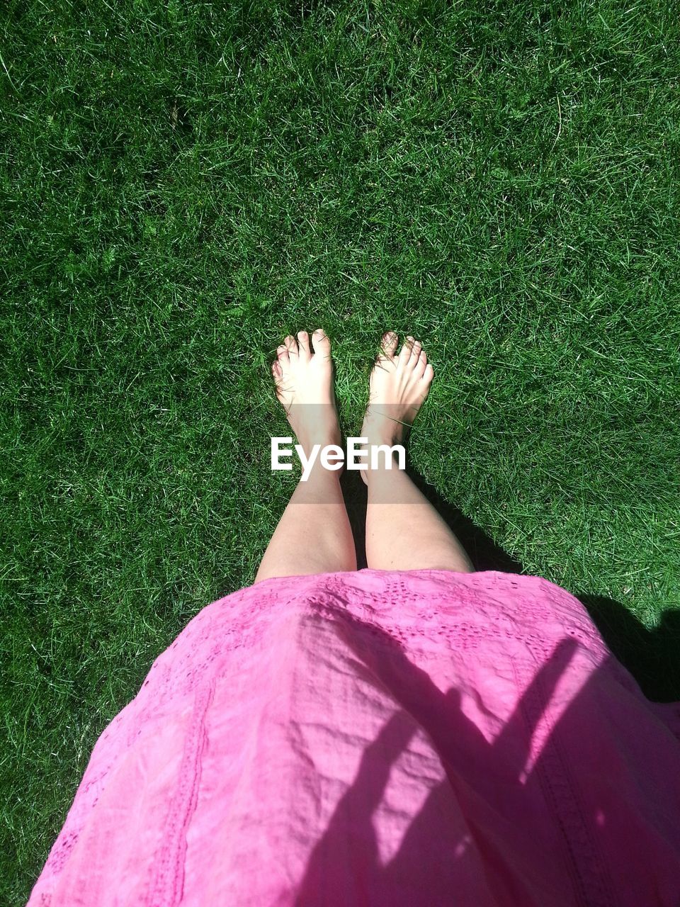 Low section of woman standing on grassy field