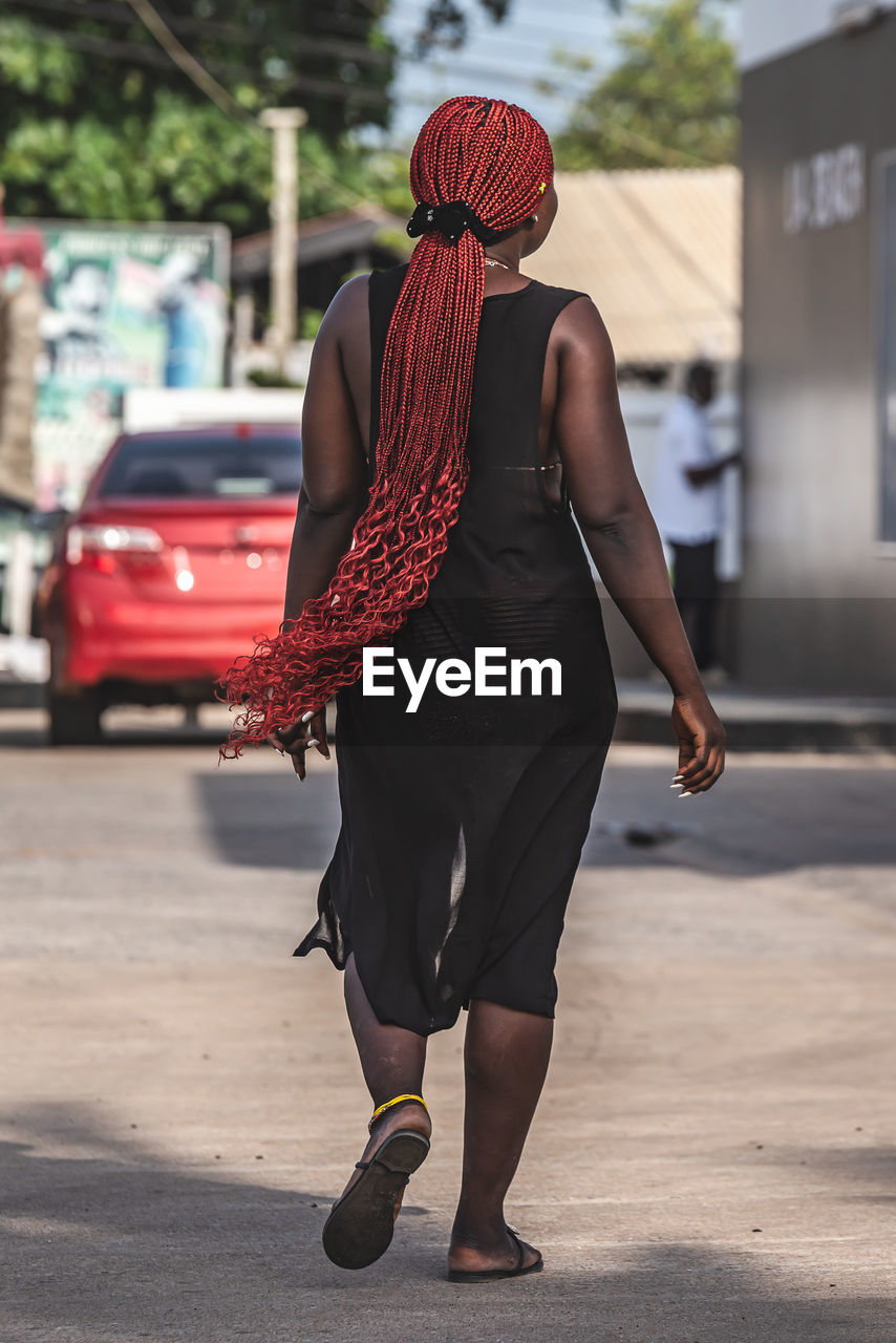 FULL LENGTH REAR VIEW OF WOMAN WALKING ON STREET