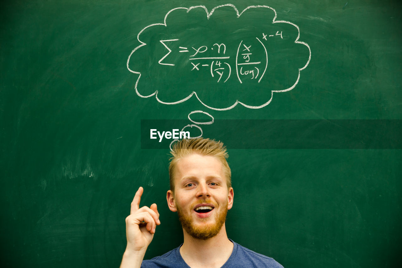 Man with mathematical formula on blackboard