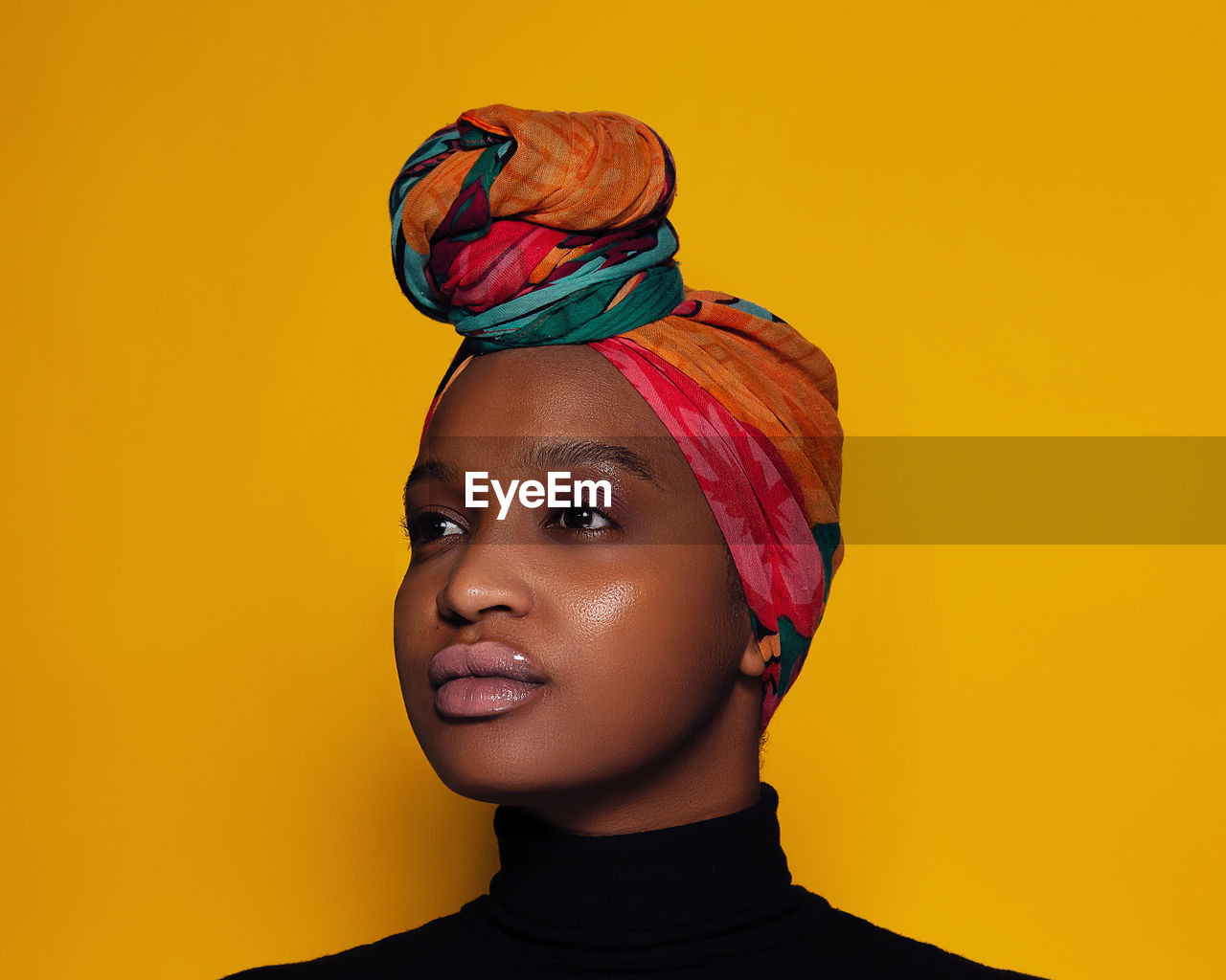 Close-up of woman wearing headscarf against yellow background