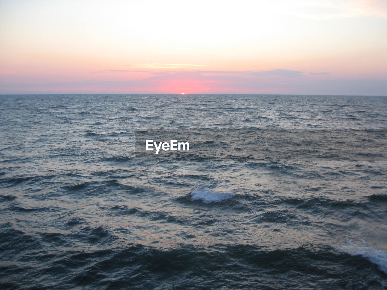 sea, sky, water, sunset, horizon over water, beauty in nature, horizon, scenics - nature, ocean, tranquility, nature, tranquil scene, idyllic, seascape, sun, wave, environment, no people, urban skyline, motion, cloud, wind wave, dramatic sky, land, outdoors, travel, dusk, coast, sunlight, blue, travel destinations, shore, beach, landscape, non-urban scene, orange color