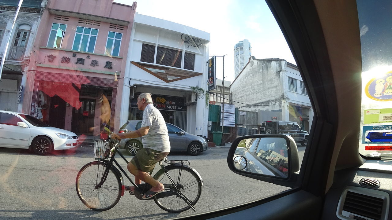 MAN RIDING BICYCLE ON CITY STREET