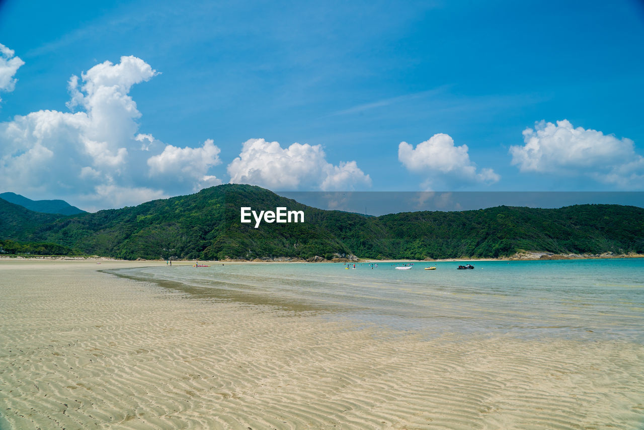 Scenic view of beach against blue sky