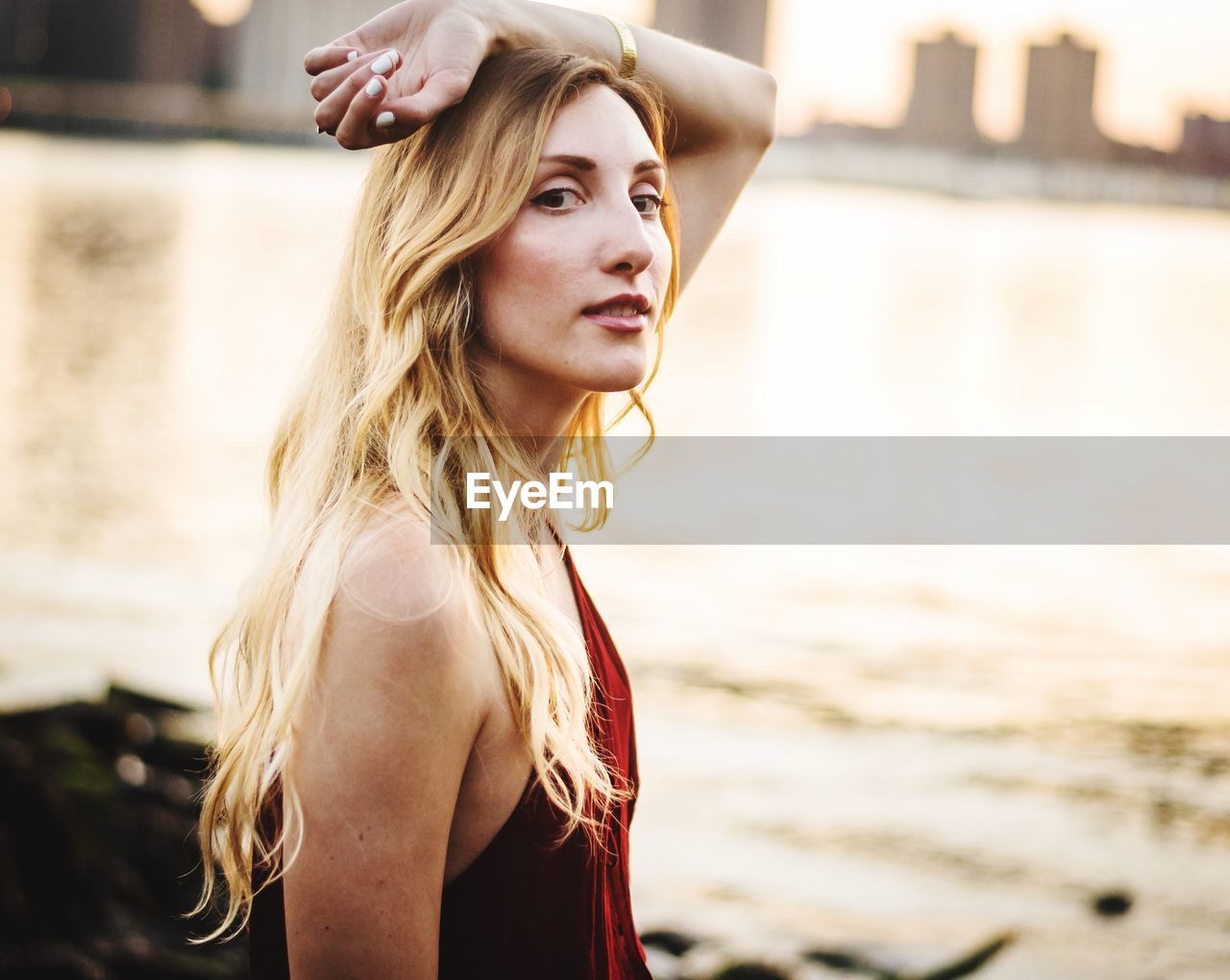 PORTRAIT OF WOMAN STANDING AGAINST WATER