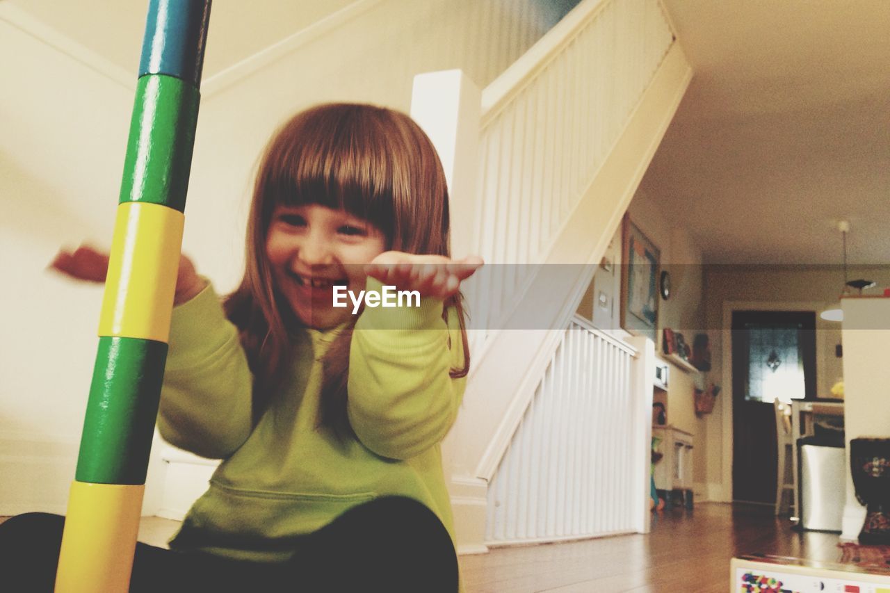 Cheerful girl gesturing while playing at home