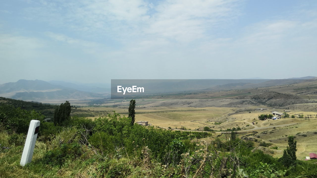 SCENIC VIEW OF GRASSY LANDSCAPE AGAINST SKY