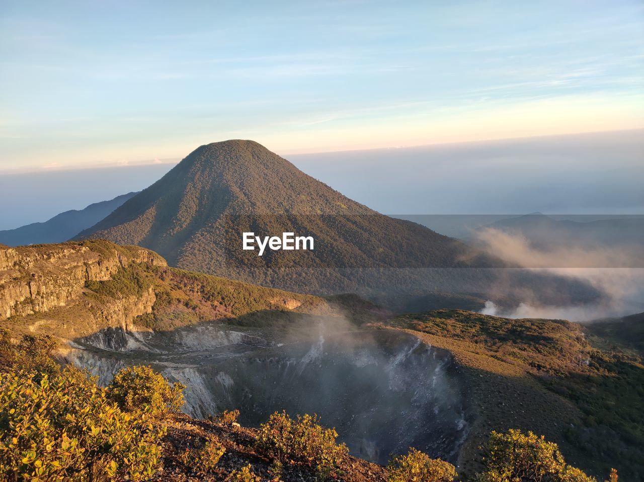 Scenic view of volcanic mountain against sky during sunset